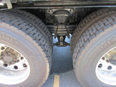 Dual rear wheels and drivetrain view under a Western Star truck showing axles and suspension components.
