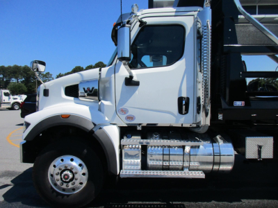 Western Star 47X dump truck side view showing cab and chrome diamond-plate fuel tank with steps.
