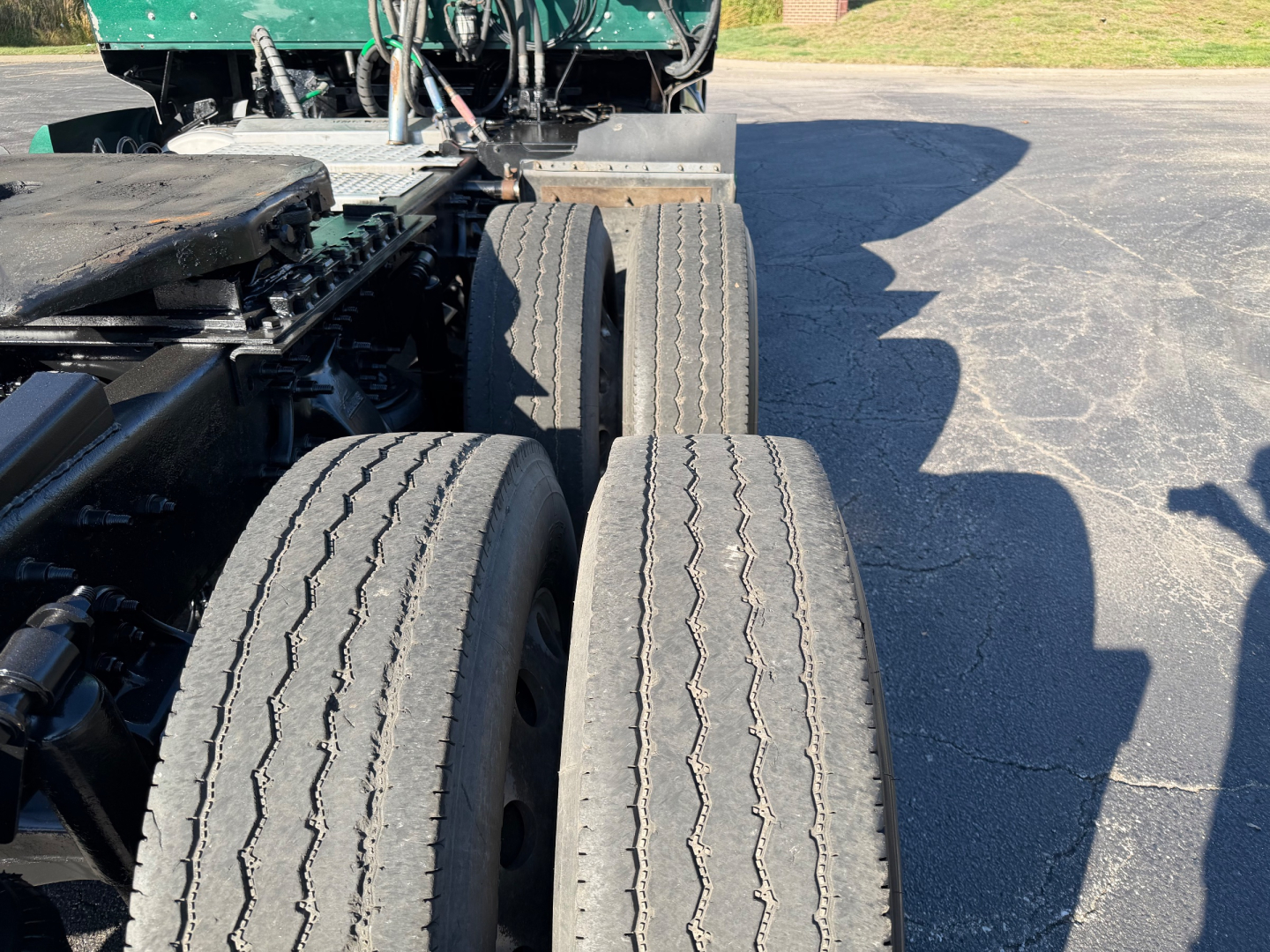 Western Star 5700XE truck chassis with dual rear axles and spare tires visible. Flatbed and tractor components in view.