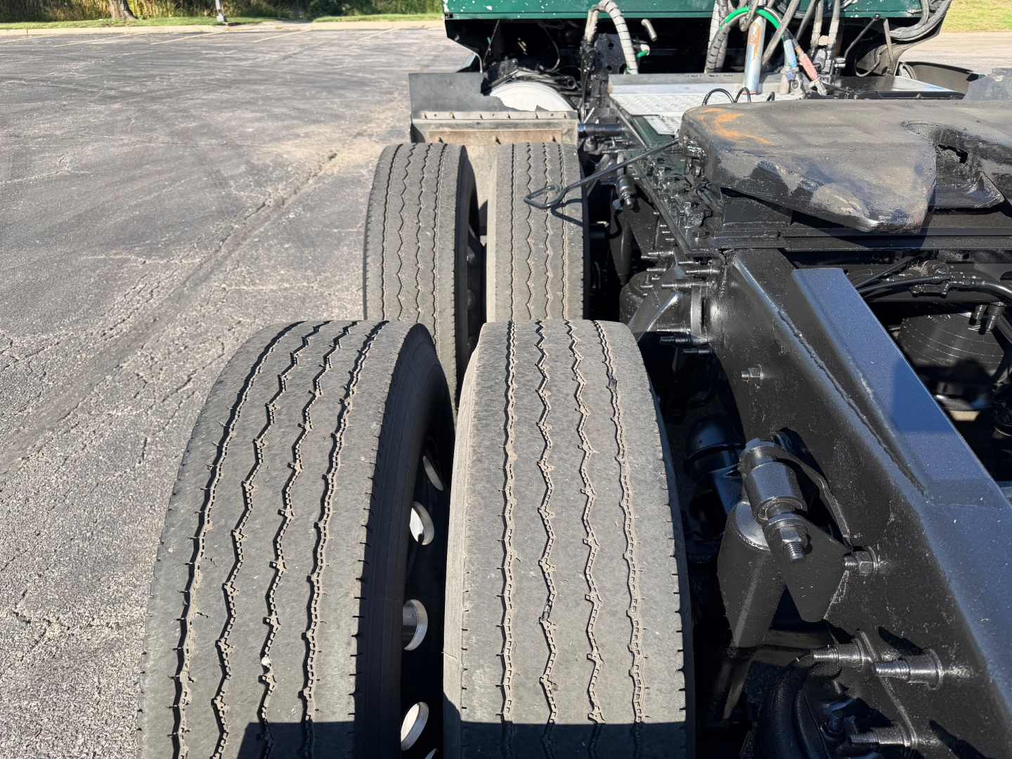 Western Star 5700XE truck chassis showing dual rear axles and tires with visible drive train components and frame.
