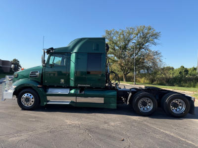 2017 Western Star 5700XE sleeper cab tractor in green, side view showing 6x4 axle configuration and dual rear axles with chrome fuel tanks and steps.
