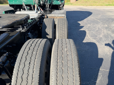 Western Star 5700XE truck chassis with dual rear axles and spare tires visible. Flatbed and tractor components in view.