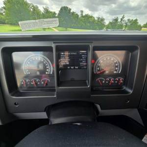 Mack PI64T dashboard view showing gauges and central digital display with vehicle totals and controls.