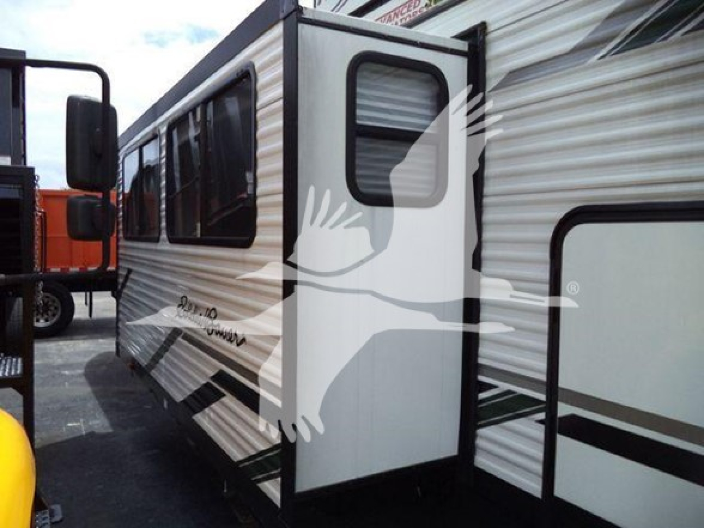 Travel trailer side with slide-out extended showing graphic and windows