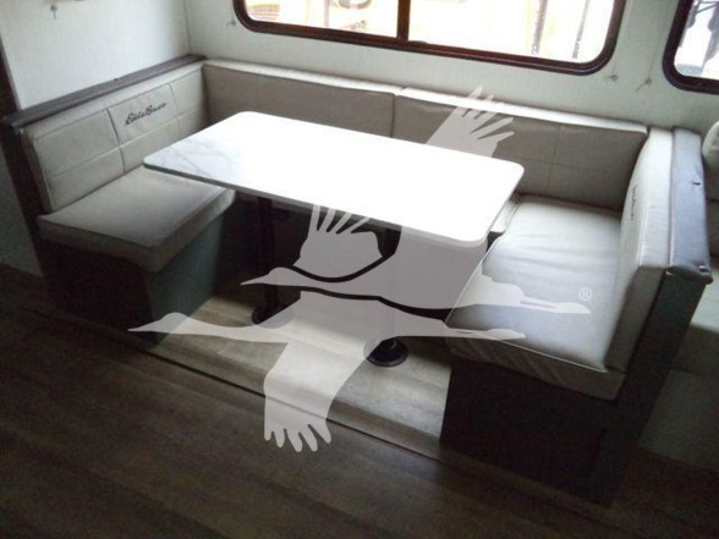 Interior of trailer dining area with L-shaped bench seating around a rectangular table