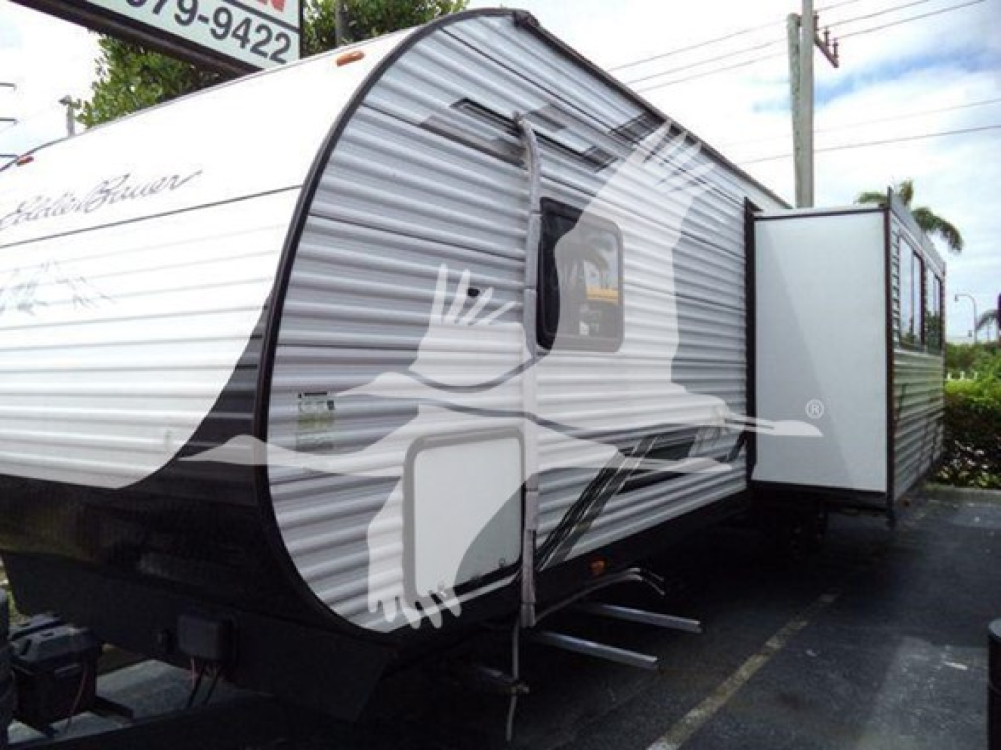 Travel trailer from 2024 Unknown 322Bh, side view with slide-out extended; exterior is white with gray stripes and a bear graphic on the front. VIN 5SFYB3728RM536607.
