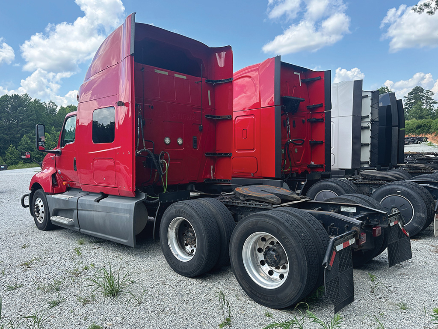 2019 International LT625 tractor side/back view showing red sleeper cab and dual rear axles.