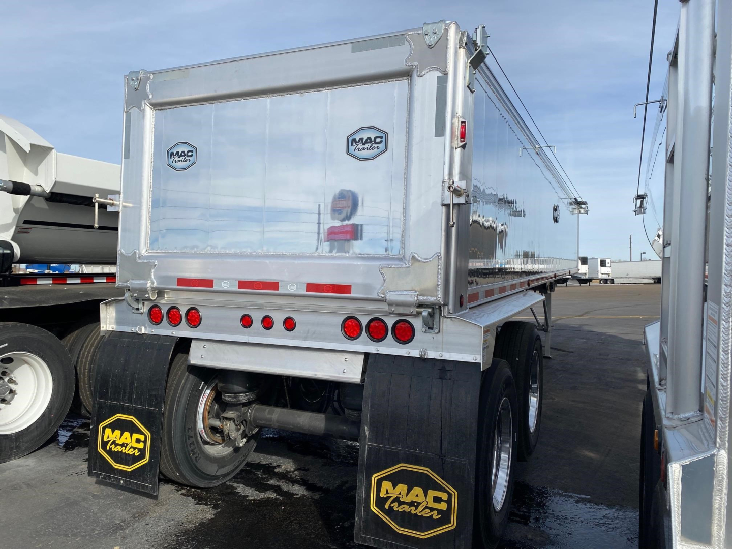 Mac Western Lightweight aluminum end dump trailer rear view showing aluminum sides, tailgate, hydraulic components, and MAC Tires mudflaps.