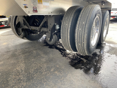 Trailer axle area showing dual rear wheels and suspension undercarriage of a Mac Western lightweight aluminum end dump.