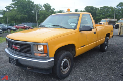 GMC Sierra 2500 pickup truck in yellow, single cab long bed, viewed from front-left angle.