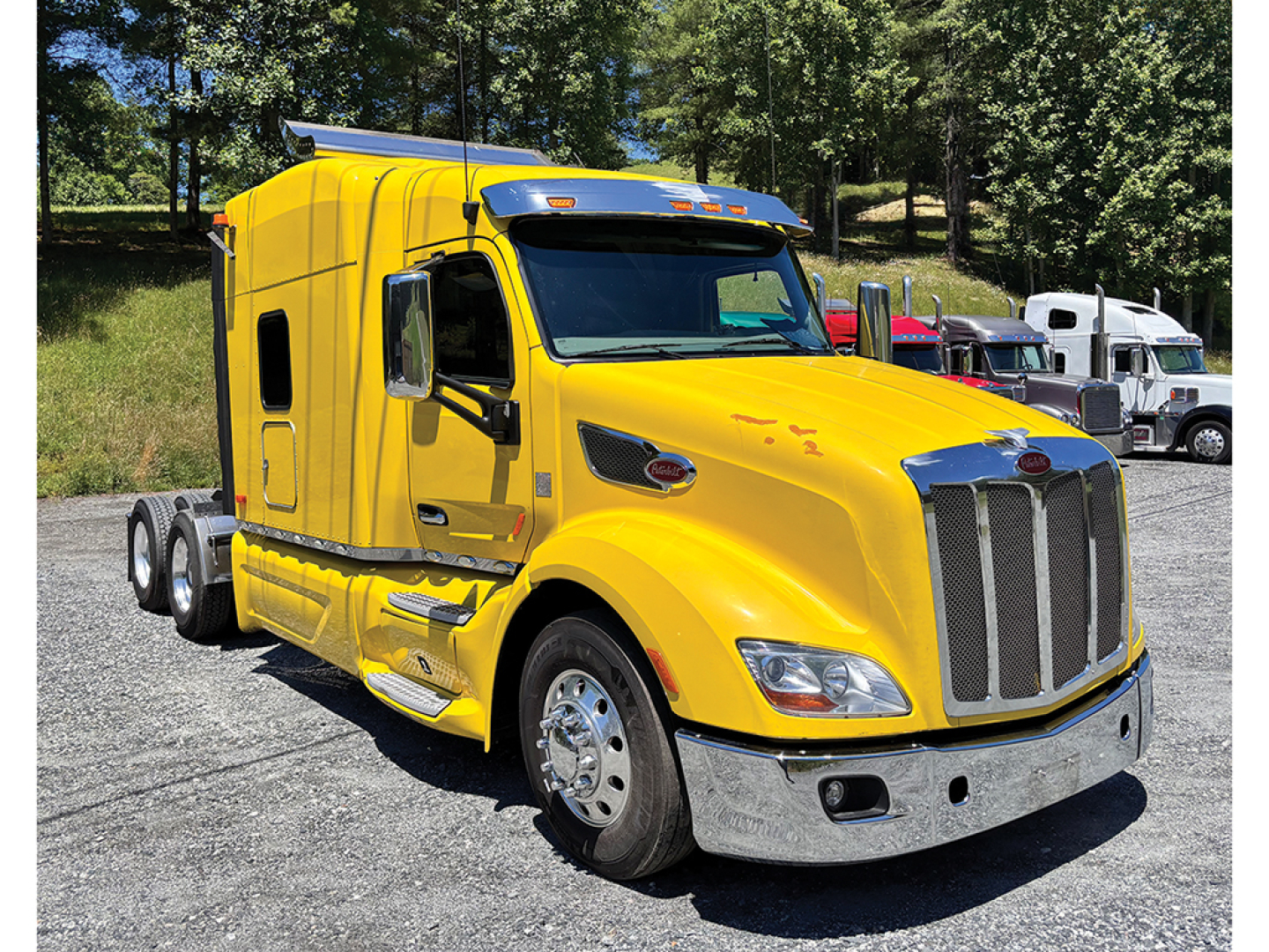 Yellow Peterbilt 579 UltraCab semi-truck front and side view in a lot