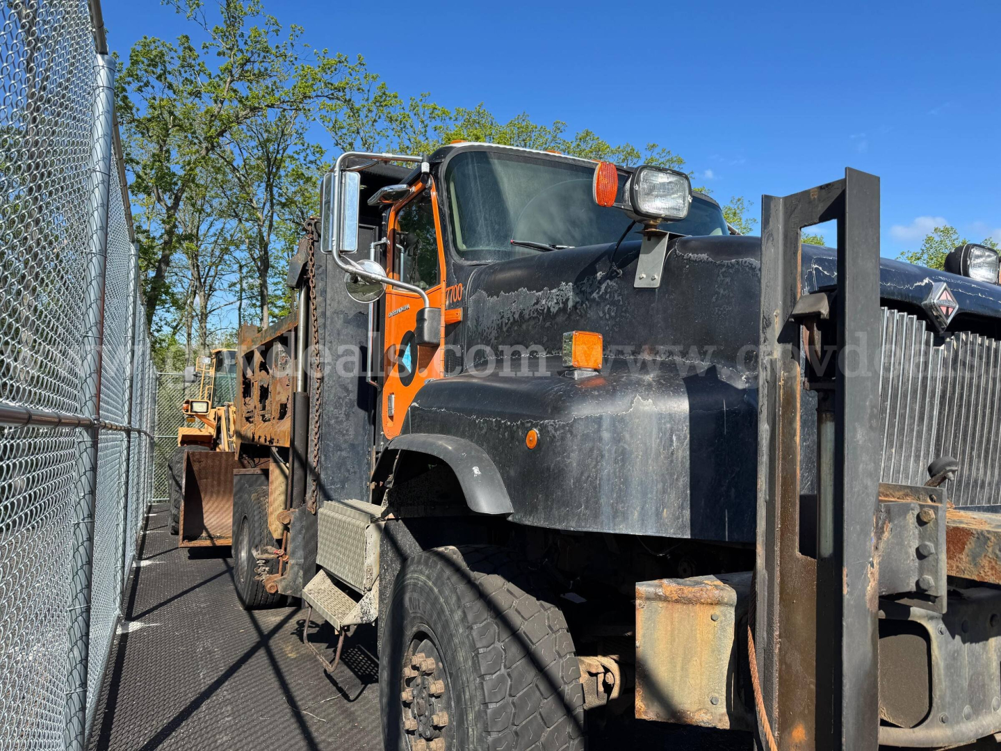 Dump truck cab and bed of a 2004 International 5600i with black and orange exterior, visible front grille, headlights, and side mirrors.