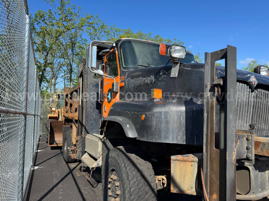 Dump truck cab and bed of a 2004 International 5600i with black and orange exterior, visible front grille, headlights, and side mirrors.