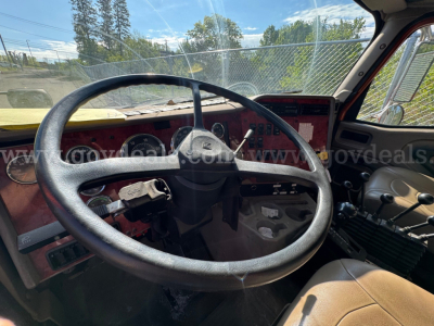 Interior of a 2004 International 5600i dump truck showing steering wheel, dashboard, and driver seat.