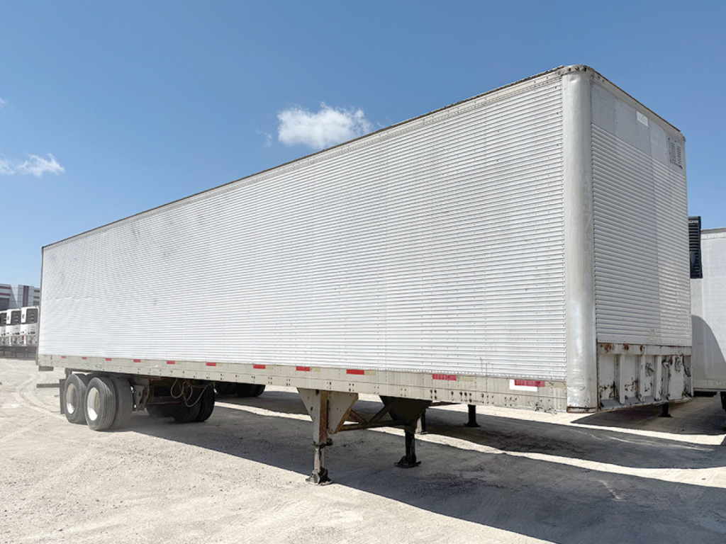 Aluminum Hobbs van trailer on a trailer stand with wheels visible and a clear blue sky.