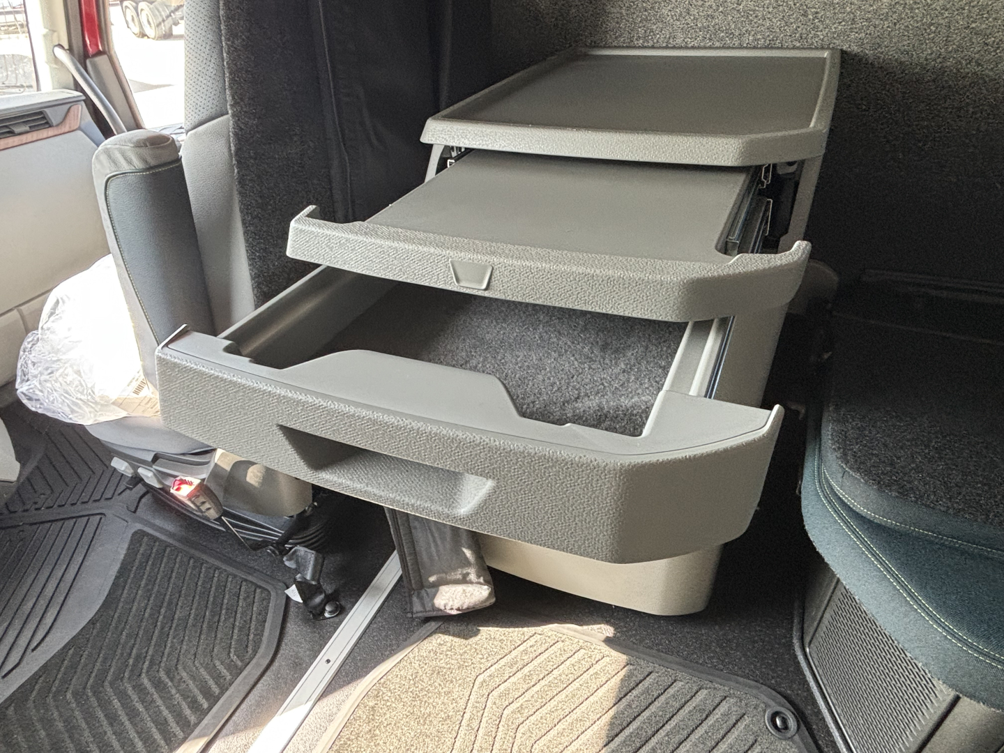 Volvo VNL64T860 interior showing three-tier plastic storage drawers extended from the cab wall.