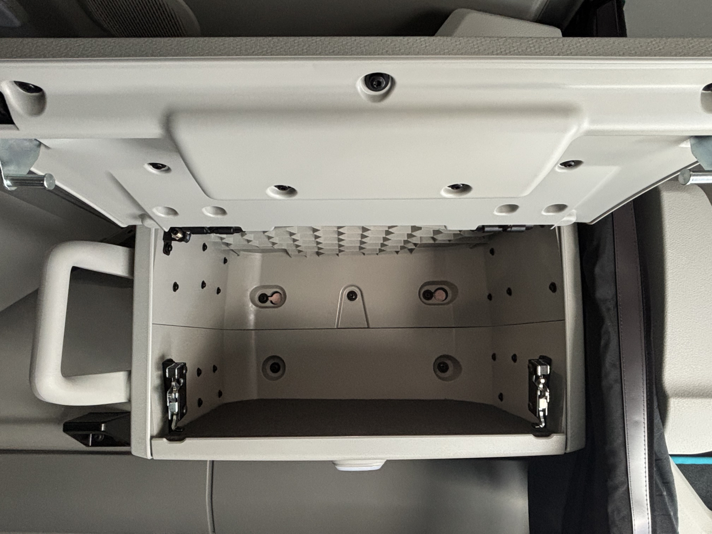 Volvo VNL64T860 cab interior showing under-dash storage compartment with metal interior and latching hinges.