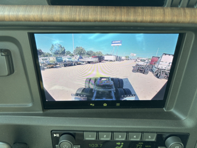 Volvo VNL64T860 dashboard display showing view from the cab with trucks in a dealership lot.