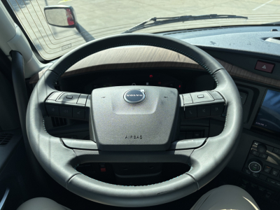 Volvo steering wheel and dashboard view inside a new Volvo VNL64T860 truck cab showing steering wheel with Volvo badge and dashboard controls.