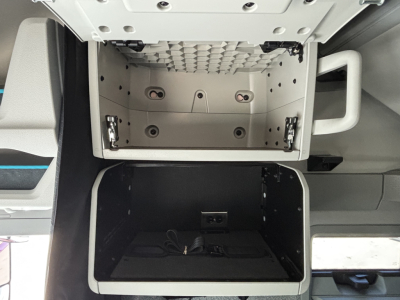 Volvo VNL64T860 cab interior showing open overhead storage and lower storage compartment under bunk with wiring visible.