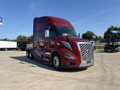 Volvo VNL64T860 truck front-left view with bold chrome grille and red cab.