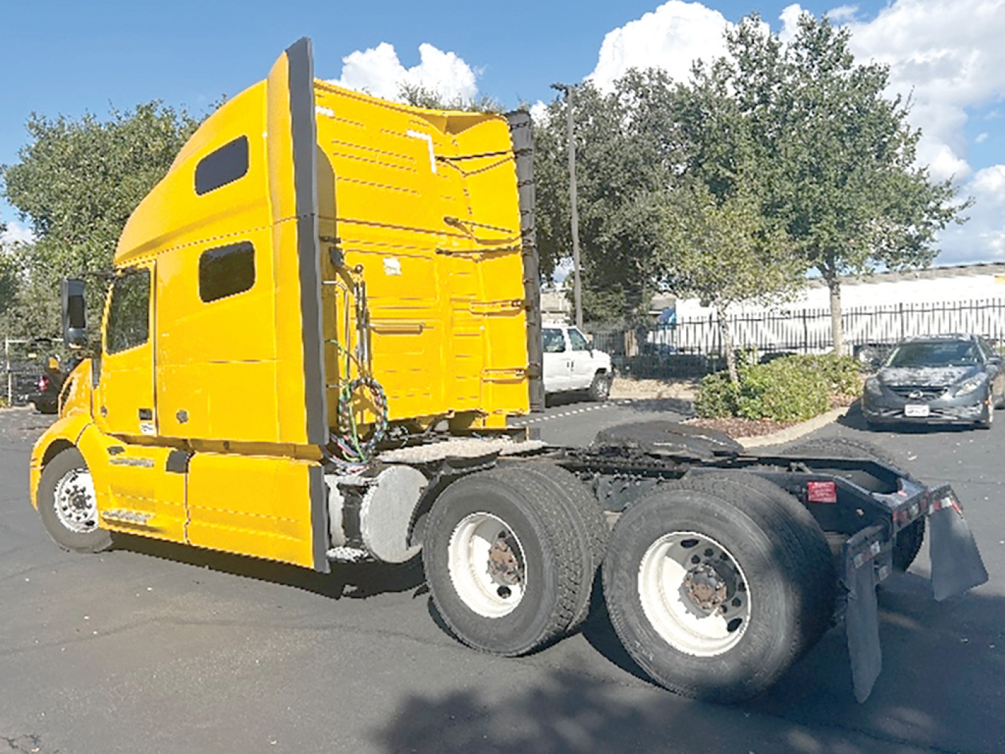 Volvo VNL 760 tractor cab in a bright yellow color, side view showing the rear chassis and wheels.