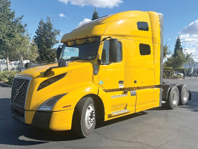 Volvo VNL 760 sleeper tractor in yellow, side view showing cab, front grille, and dual rear axles.