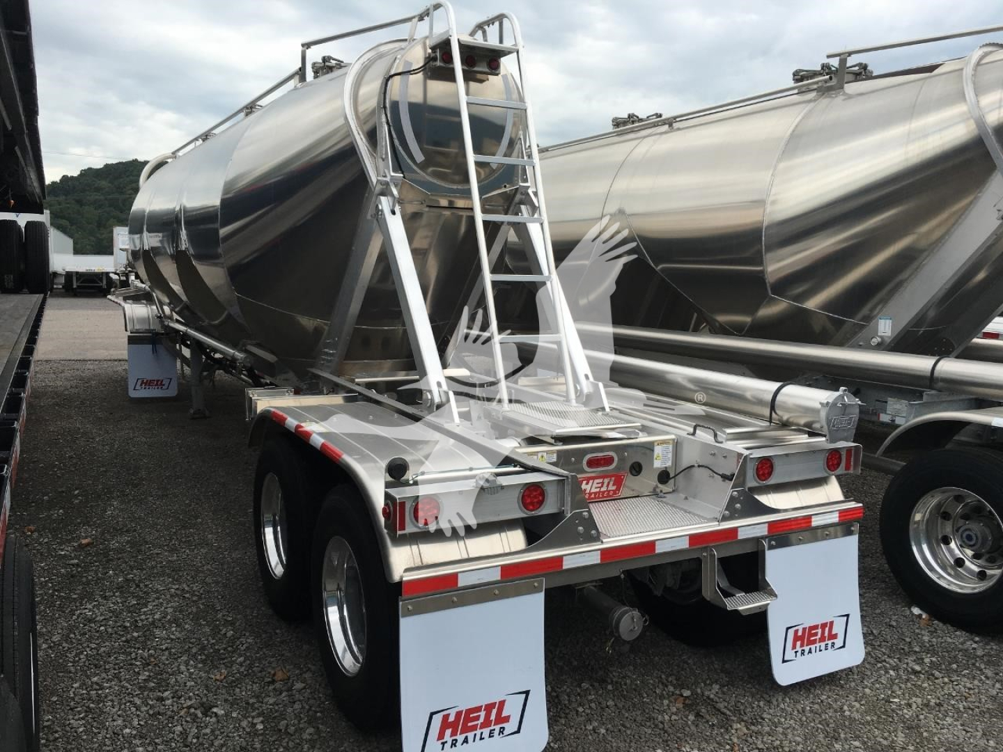 Heil Cementer pneumatic dry bulk trailer rear view showing dual axles, rear bumper, ladders, and He ul logo on mud flaps