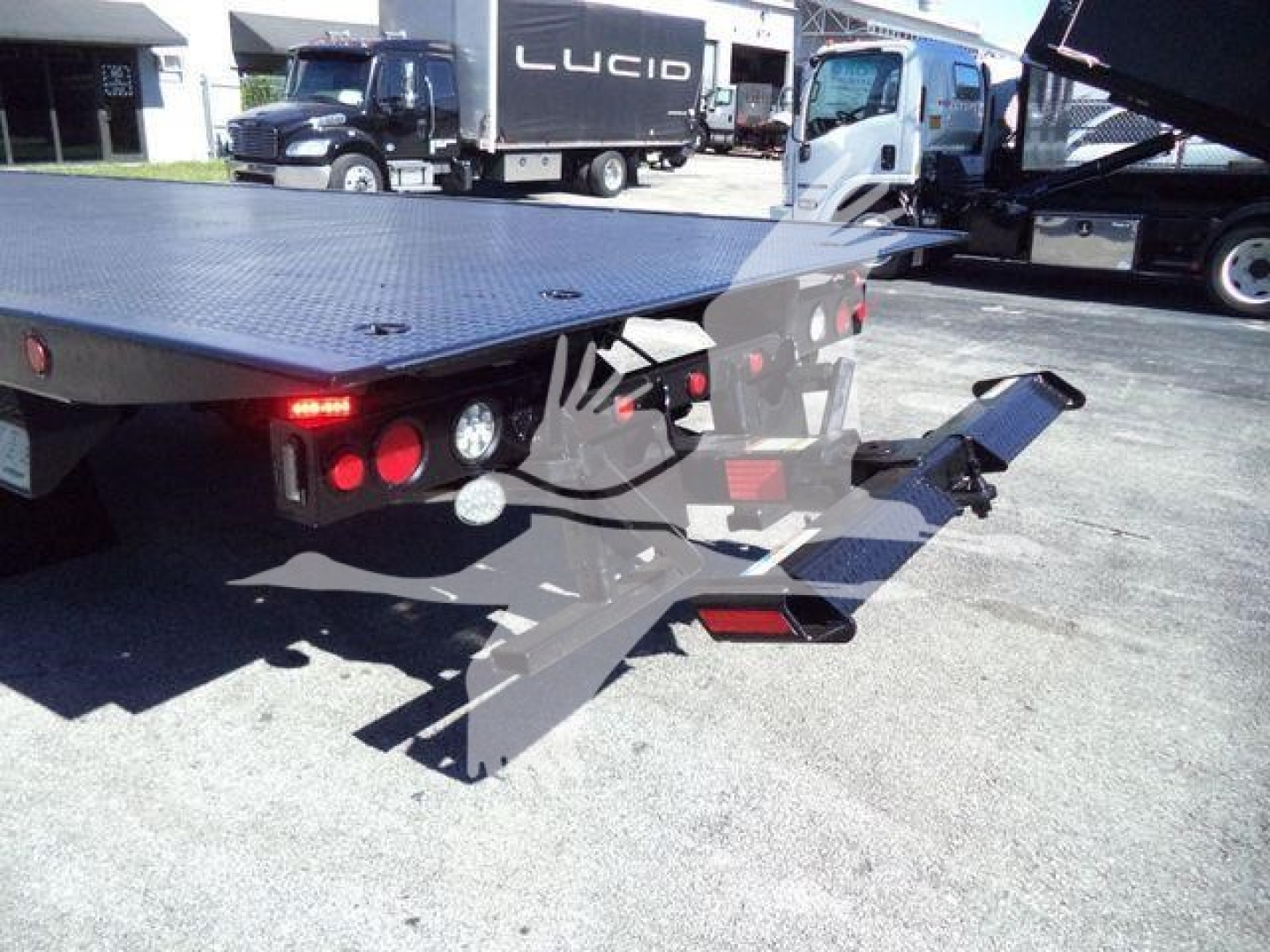 Truck rollback bed with rear lights and hydraulic ramps visible