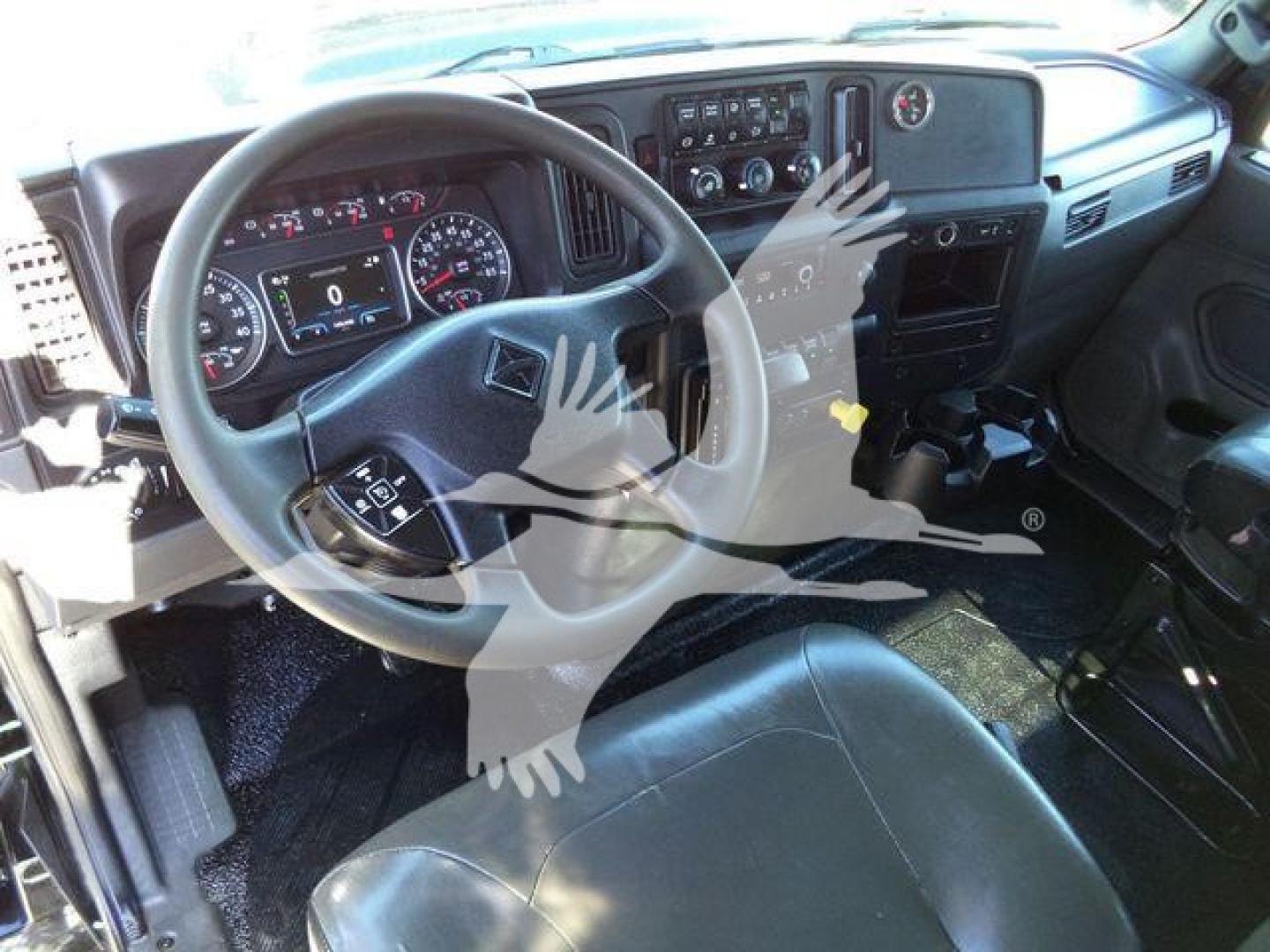 Dashboard and steering wheel of a 2022 International MV roll-back truck interior showing steering wheel, instrument cluster, center console, and gear shifter.