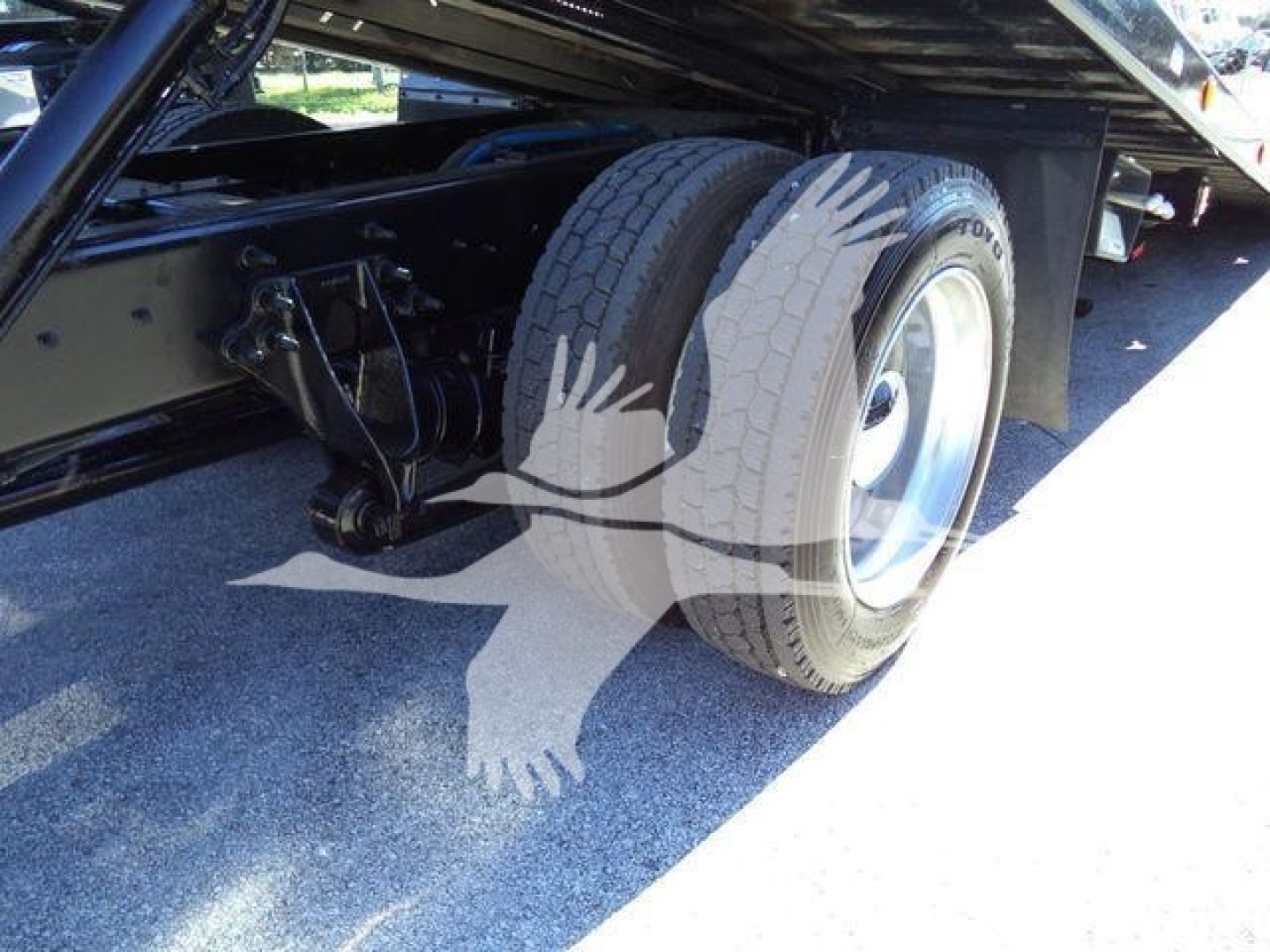 Truck chassis showing rear dual wheels and suspension undercarriage of a 2022 International MV rollback truck, with visible tires and undercarriage components.