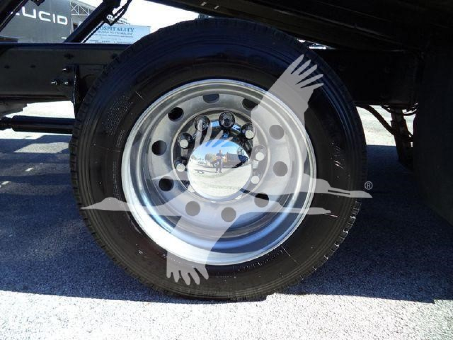 Wheel and tire of a 2022 International MV rollback truck showing steel rim with lug nuts and black tire.