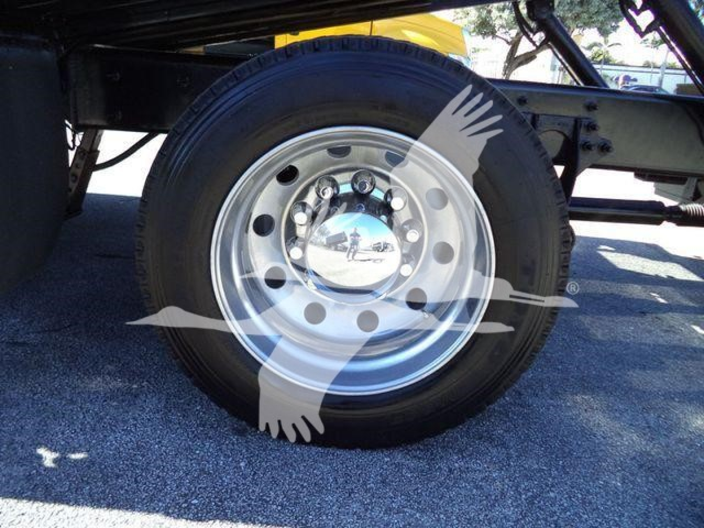 Wheel and tire of a 2022 International MV rollback truck showing chrome hubcap and steel wheel with lug studs.