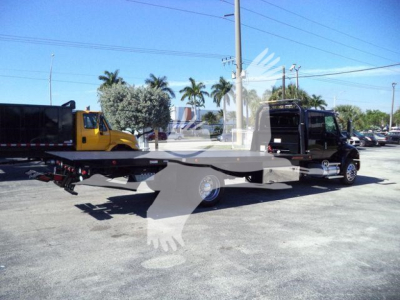 Flatbed tow truck with a black cab on a rollback trailer in an outdoor lot, International MV 2022, VIN 1HTEUMML9NH326722, stock T26722.