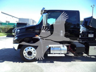 Truck cab side view showing diesel fuel tank and chrome exhaust on a black 2022 International MV rollback truck.