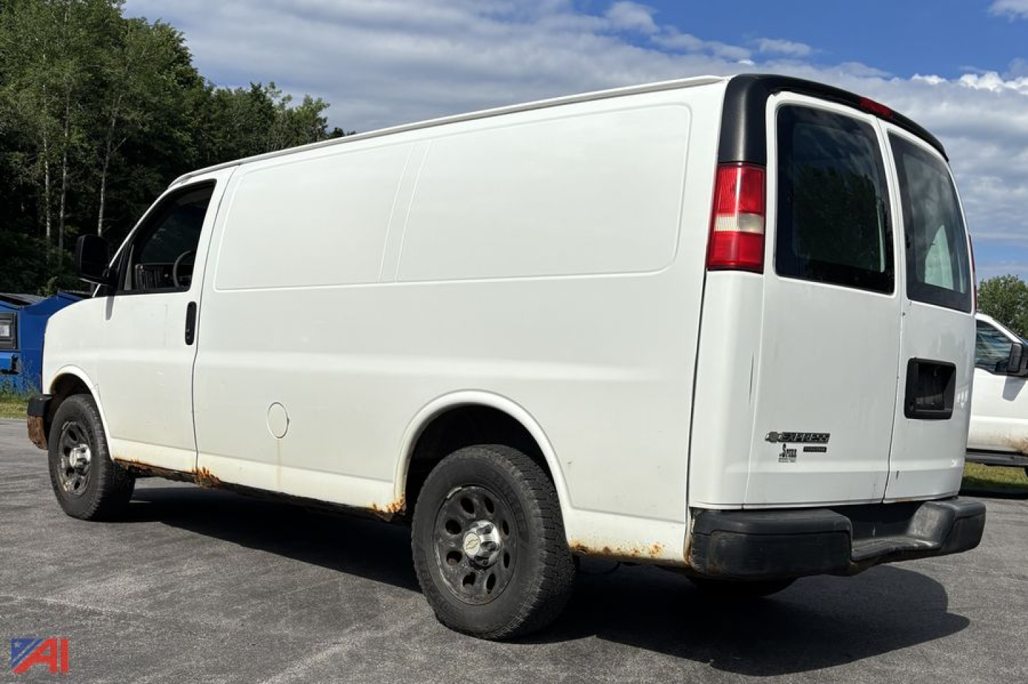 Cargo van: 2011 Chevrolet Express full-size cargo van, white, side and rear views, no windows on cargo area, black bumper, visible rust along lower body edge.