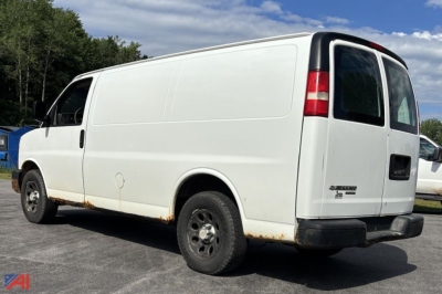 Cargo van: 2011 Chevrolet Express full-size cargo van, white, side and rear views, no windows on cargo area, black bumper, visible rust along lower body edge.