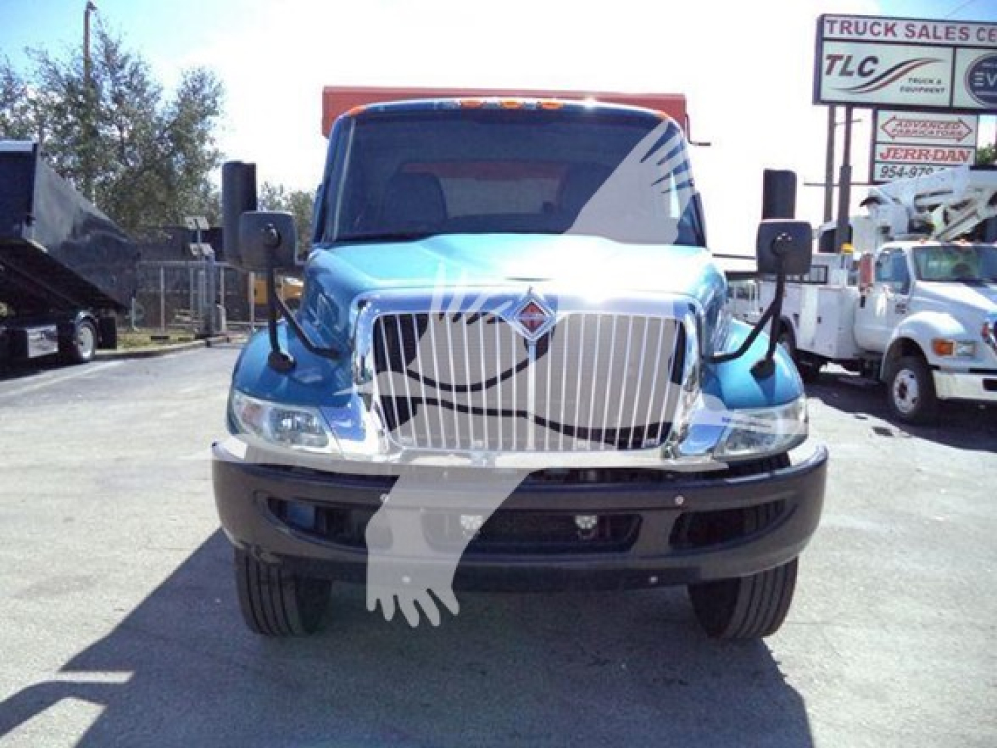 Front view of a blue 2020 International MV dump truck showing grille, headlights, and front bumper with large side mirrors.