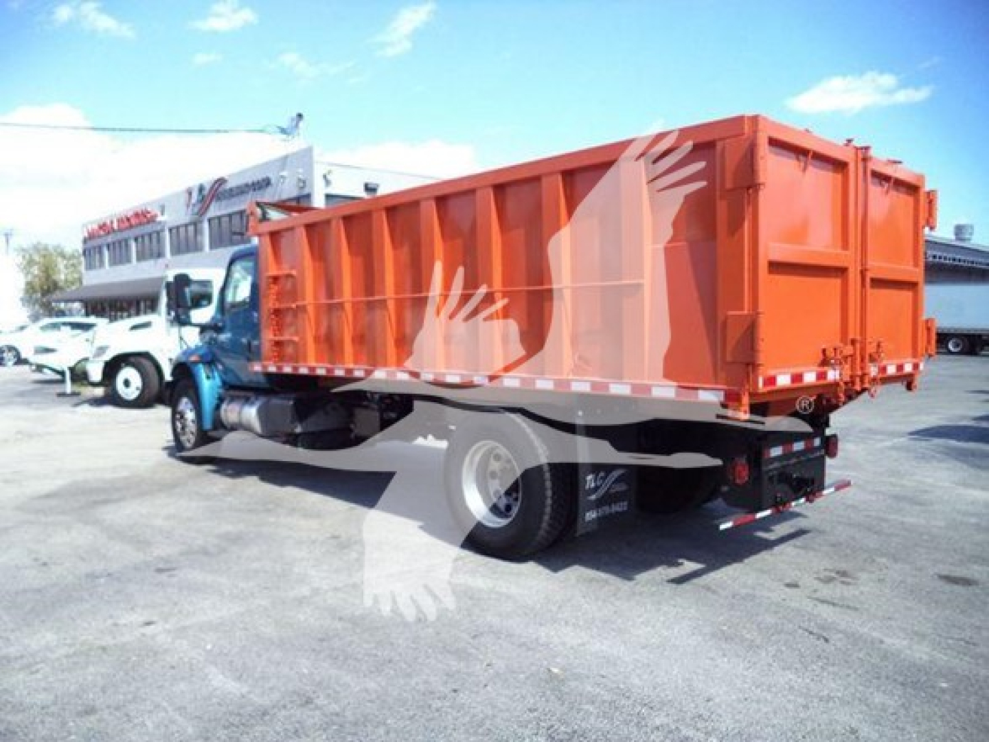 Dump truck with orange dump bed on a blue cab, side view showing rear wheels and reflective tape.