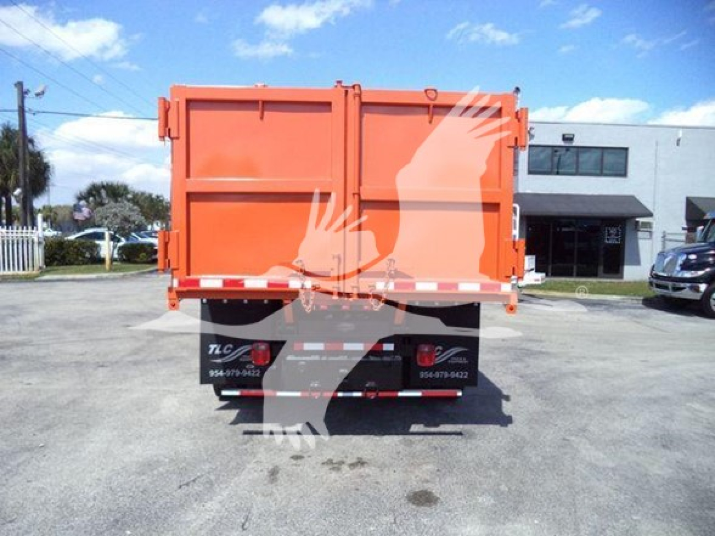 Dump truck bed tailgate showing orange dump body with reflective stripe and rear bumper, International MV likely, stock number T51680.