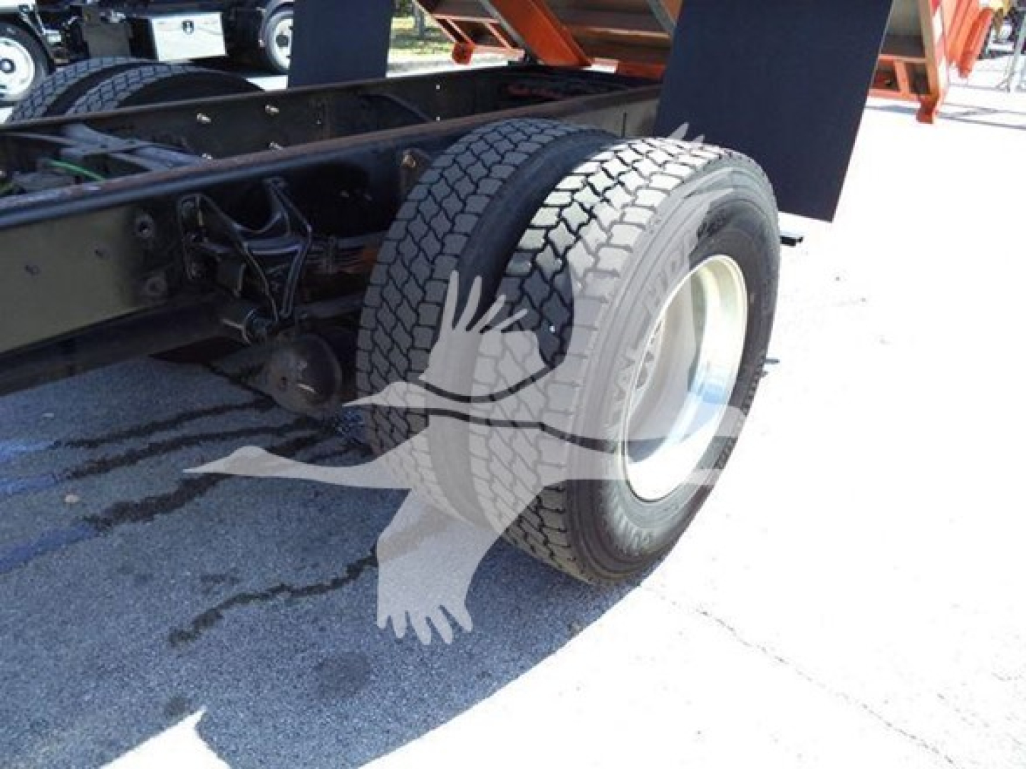 Truck rear wheel and undercarriage view showing dual rear tires and chassis components of a 2020 International MV dump truck.