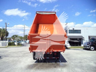 Dump truck bed of a 2020 International MV rear view showing bright orange dump body and tailgate, on a paved lot.