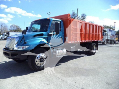 Dump truck with blue cab and orange bed, side view showing front wheel, grille, and dual rear wheels.