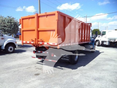 Dump truck cargo bed showing rear view with orange dump body and taillights, International MV chassis, stock number T51680.