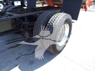 Truck rear wheel and undercarriage view showing dual rear tires and chassis components of a 2020 International MV dump truck.