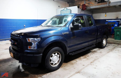Ford F-150 XL extended cab pickup truck in blue, front three-quarter view inside a workshop.