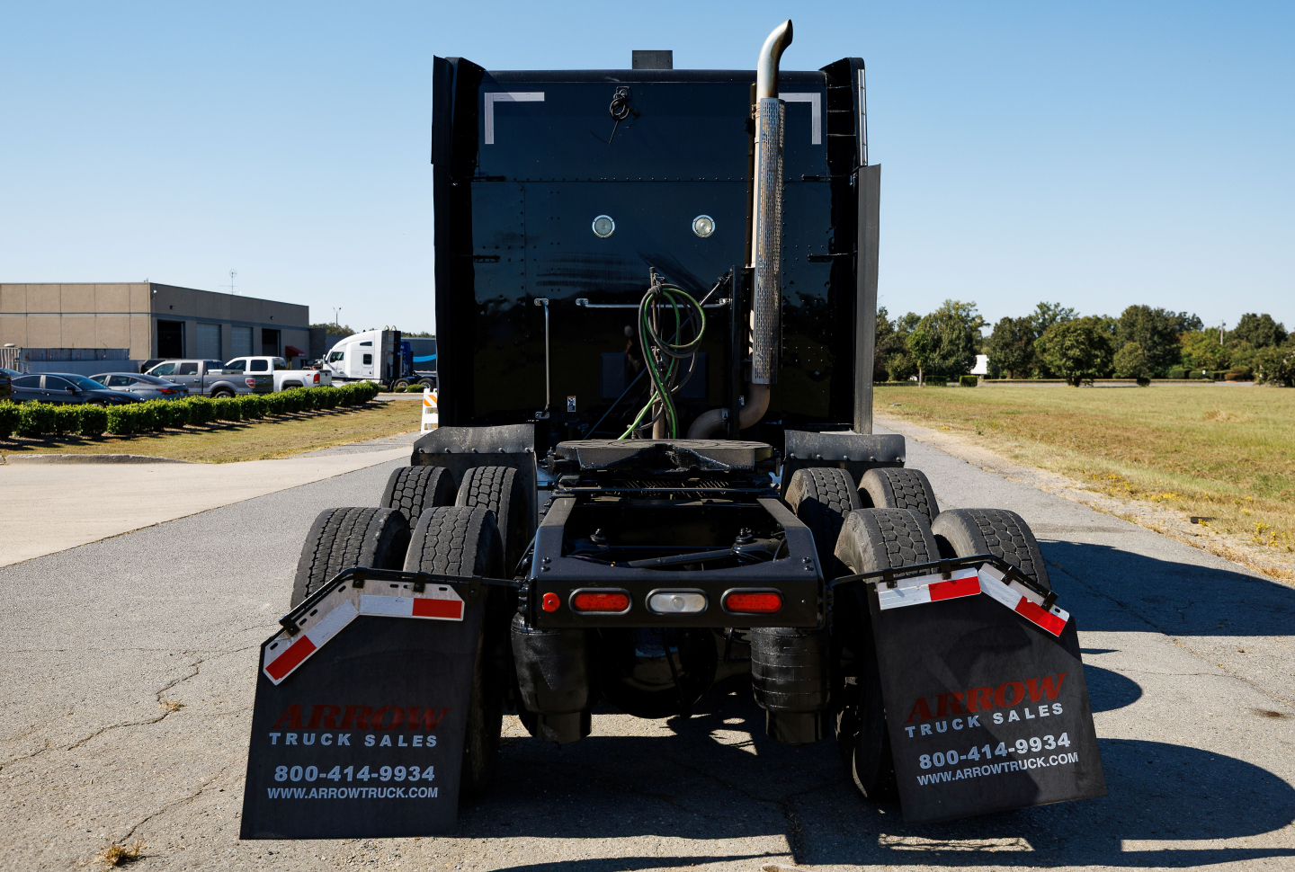 Peterbilt 579 rear view showing fender mud flaps with Arrow Truck Sales branding and dual rear wheels.