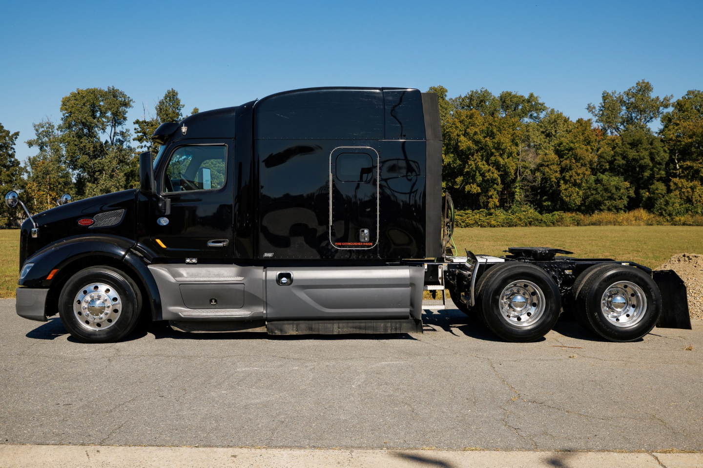 Peterbilt 579 tractor-trailer straight side profile showing black cab and chrome fuel tanks, sleeper cab, rear wheels, and chassis.