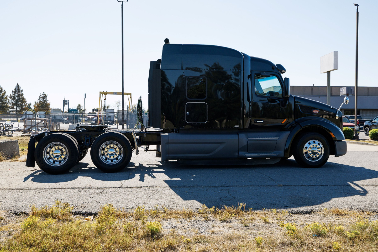 Peterbilt 579 sleeper cab truck side view showing chassis and wheels, black exterior, no trailer attached.