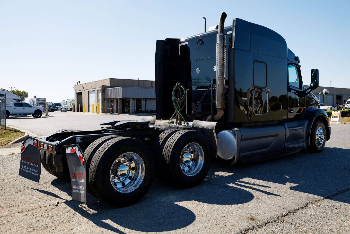 Peterbilt 579 tractor rear/side view showing dual rear axles and shiny chrome wheels, dark gloss cab, no trailer attached.